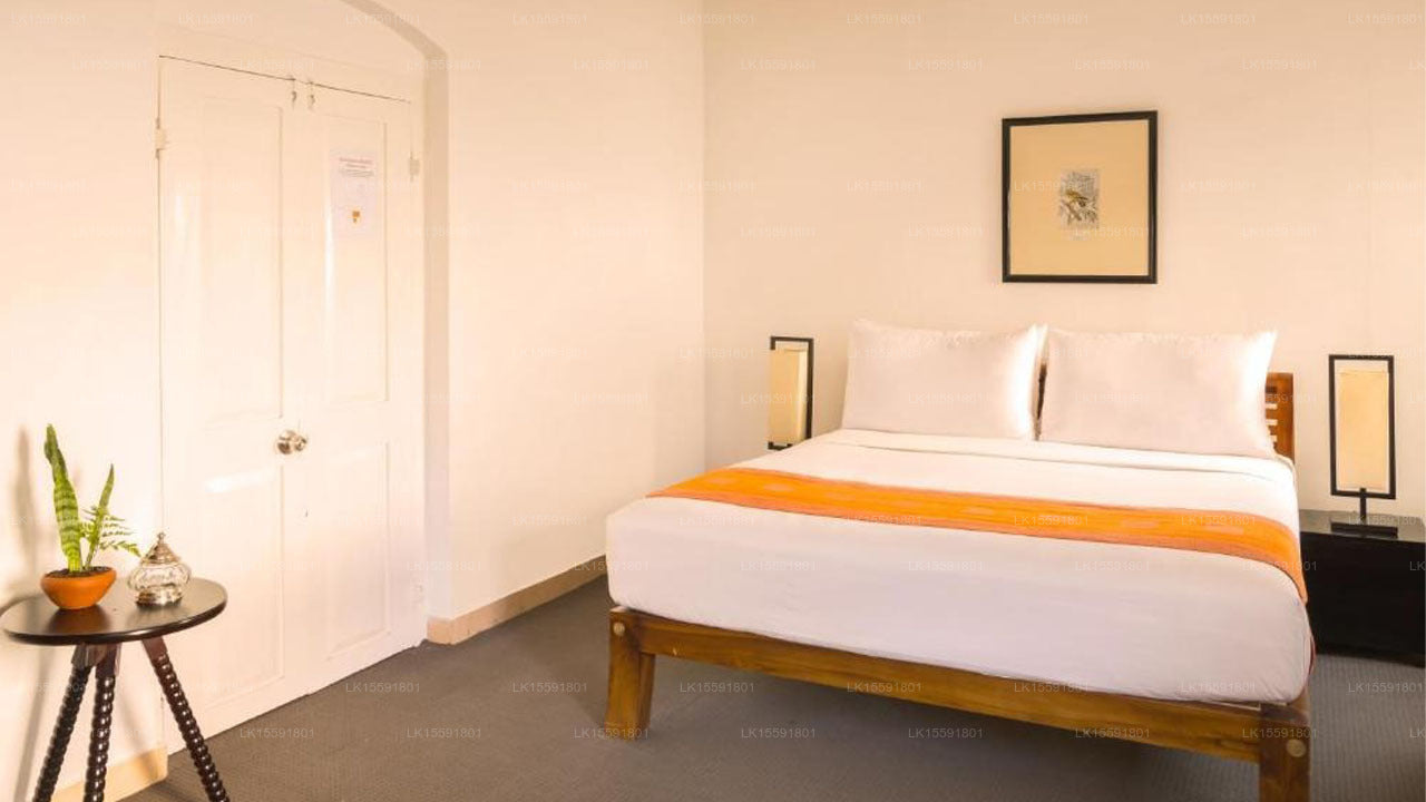 Bedroom with a neatly made bed, nightstands, and a framed picture on the wall.